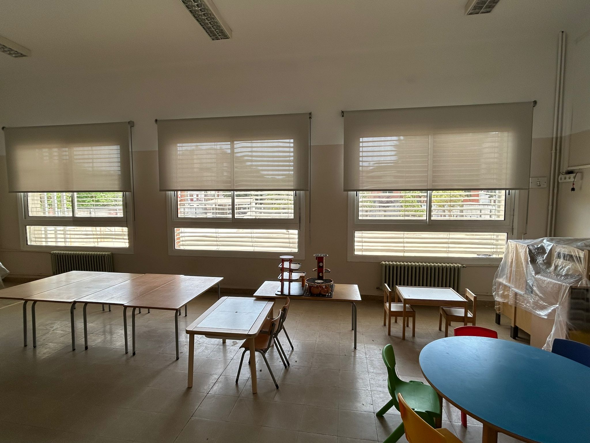 Cortinas enrollables con tejido técnico screen translúcido instaladas en ventanas de aula en Barcelona